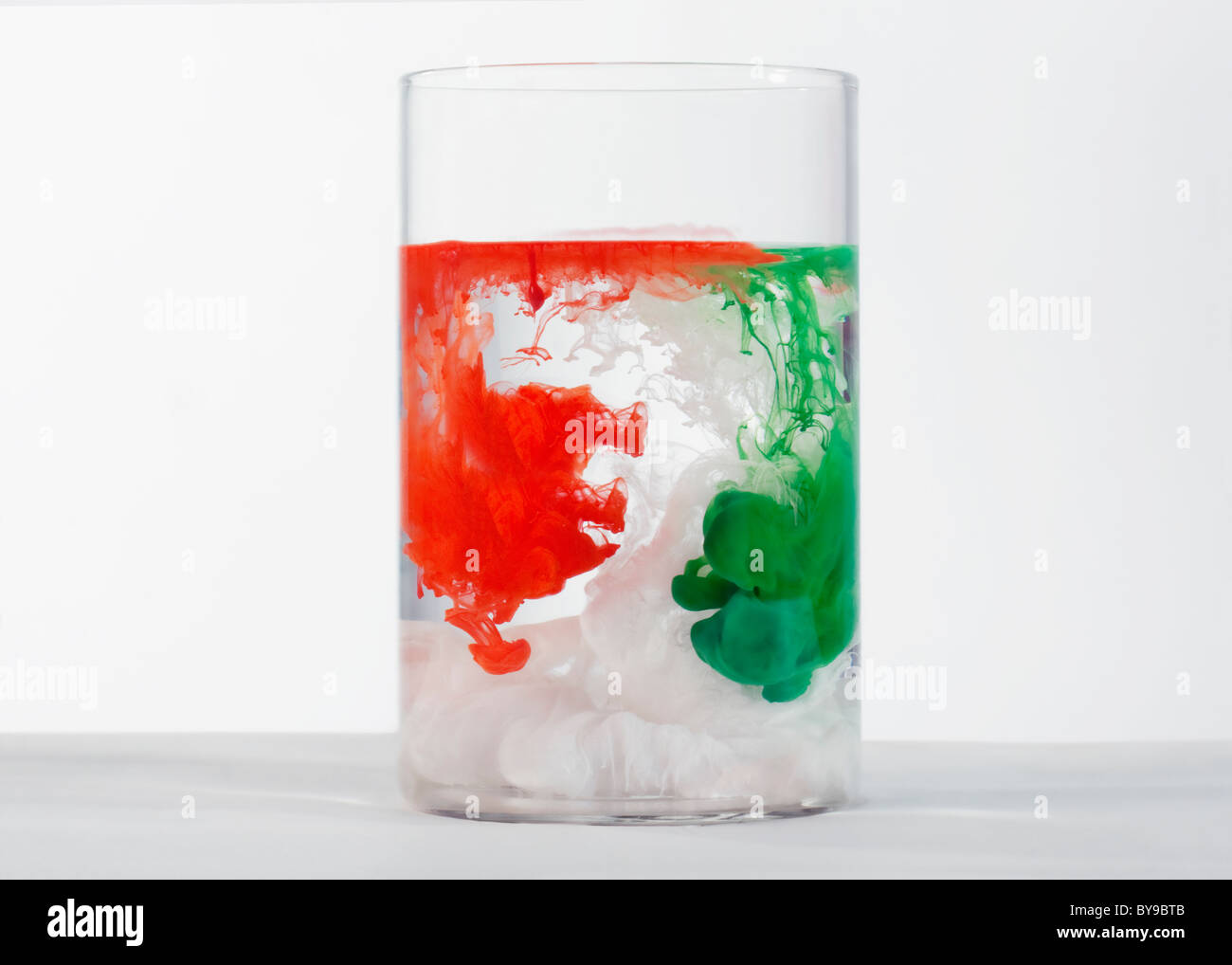 Farben auflösen in einem Glas Stockfoto