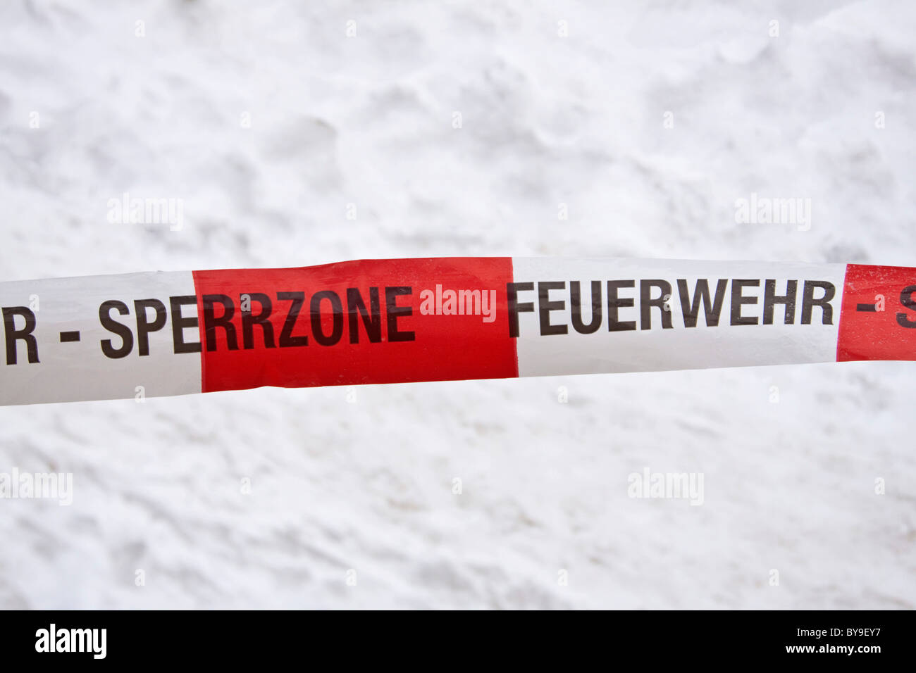 Rot-weiße Band aus der Feuerwehr Sperrzone vor Schnee Stockfoto