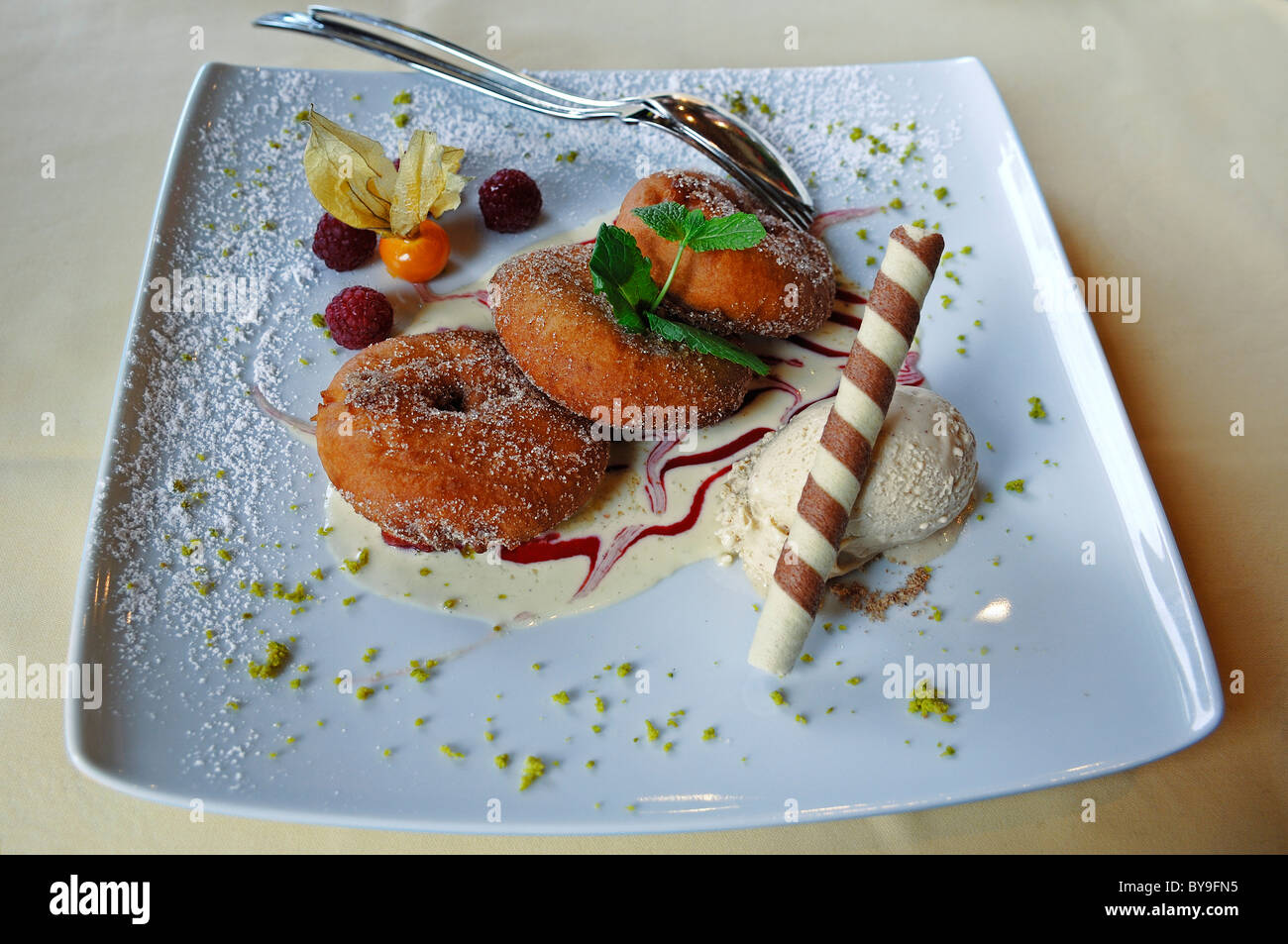 Apfelringe mit Vanille-Eis auf einem weißen Teller dekoriert Stockfoto