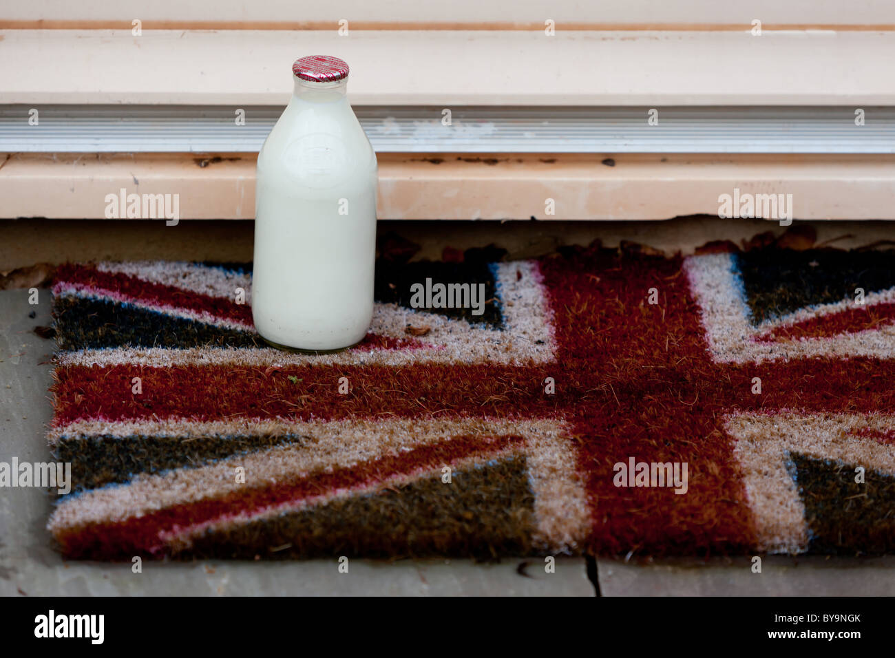 Ein Pint Milch vor eine Haustür mit Anschluß-Markierungsfahne Fußmatte Stockfoto