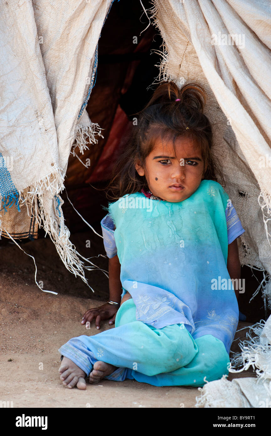 Arme indische Mädchen am Eingang von ihr Zelt nach Hause sitzen aus Kunststoff Plünderungen. Andhra Pradesh, Indien Stockfoto