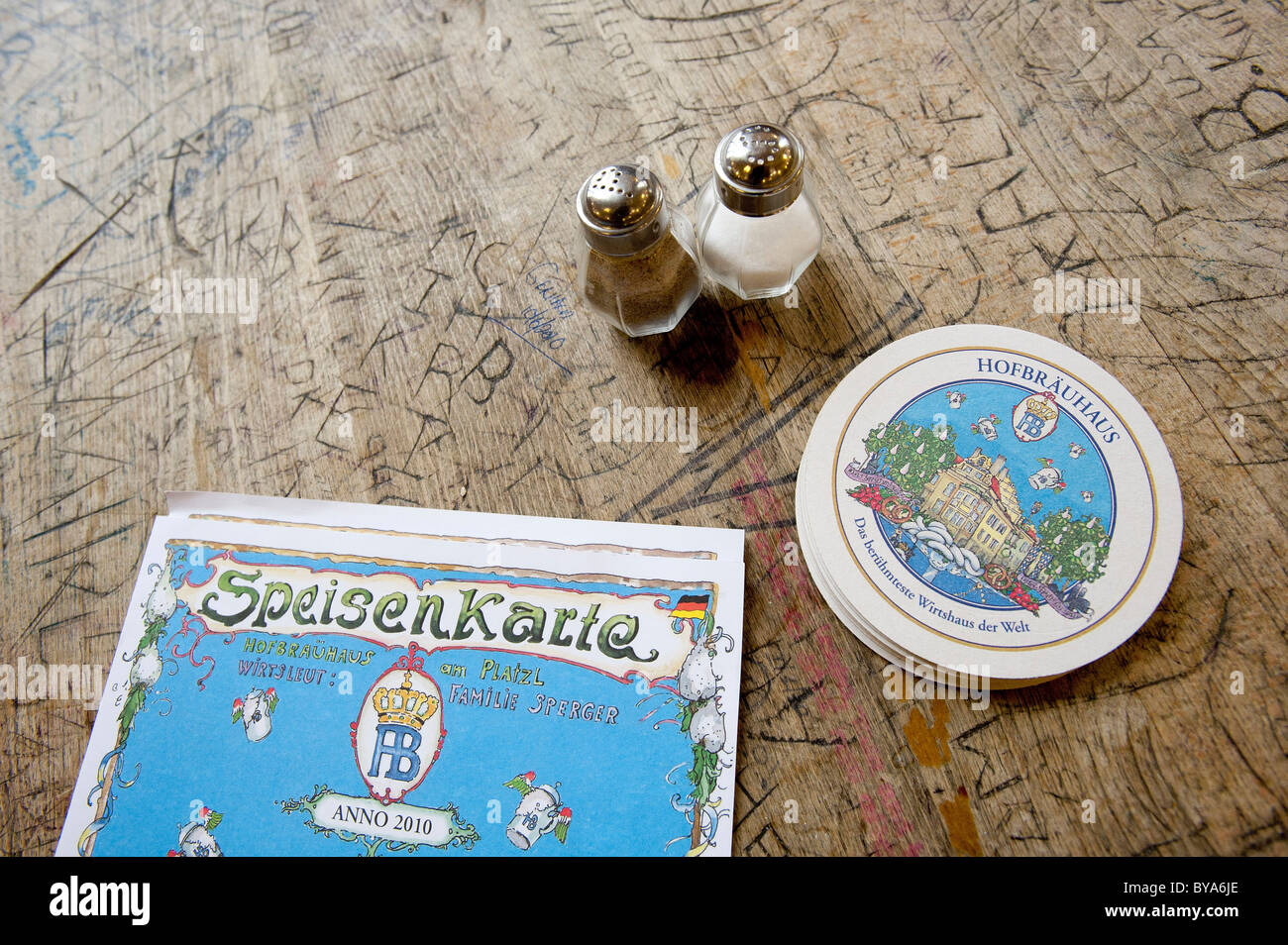 Salz- und Pfefferstreuer, Bierdeckel und ein Menü auf einem Tisch im Hofbrauhaus, eine Bierhalle, Bierkultur, München, Bayern Stockfoto