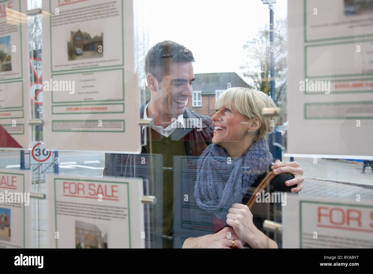 Paar auf der Suche in Immobilienmakler Fenster Stockfoto