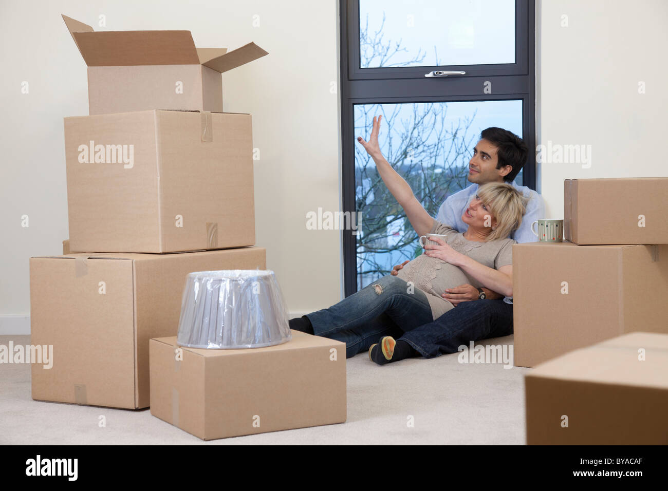 Paar saß unter Boxen in Wohnung Stockfoto