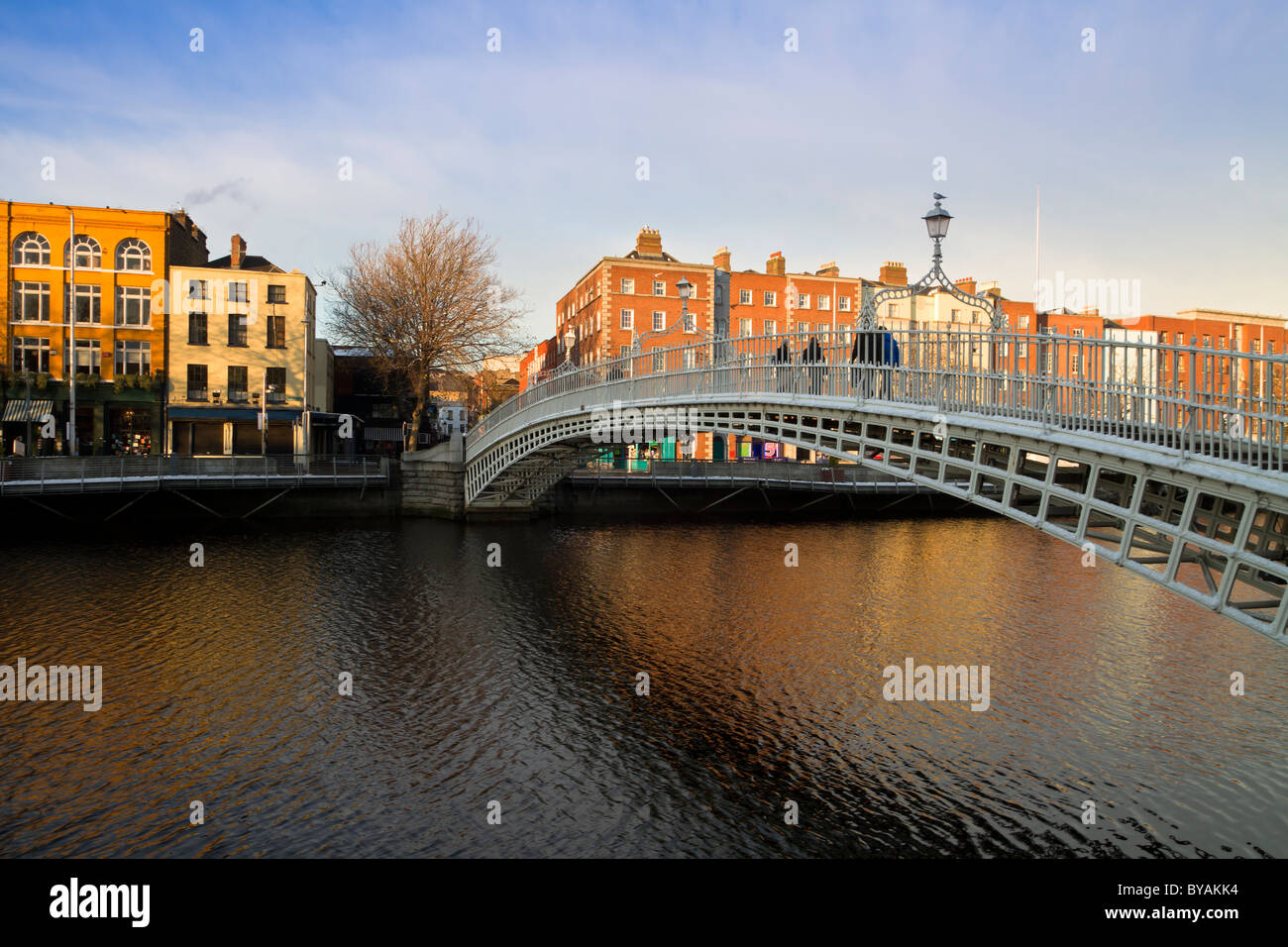 Dublin Wahrzeichen - Ha'penny Brücke am Fluss Liffey. Reihen von bunten Häusern. Stockfoto