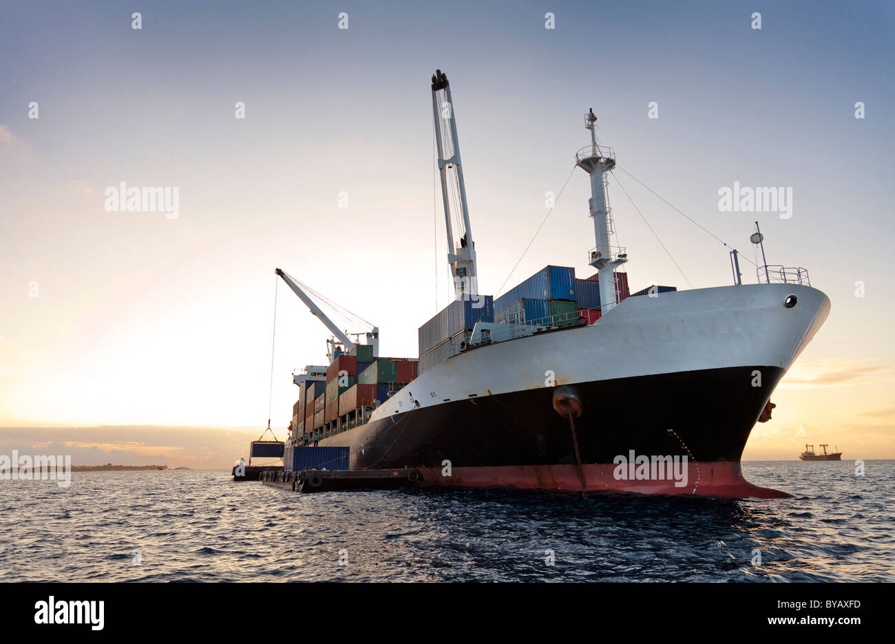 Ein Container Schiff be-und Entladen Container im Anchorage auf Lastkähne Stockfoto