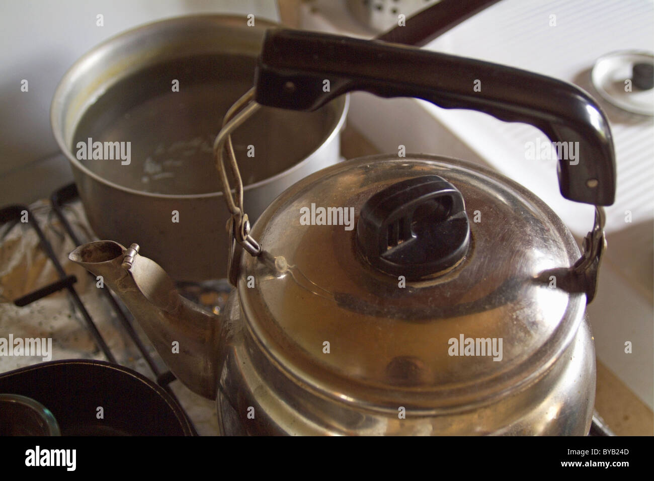 Topf füllen der Flüssigkeit und eine Teekanne auf einem Herd Ofen. Stockfoto