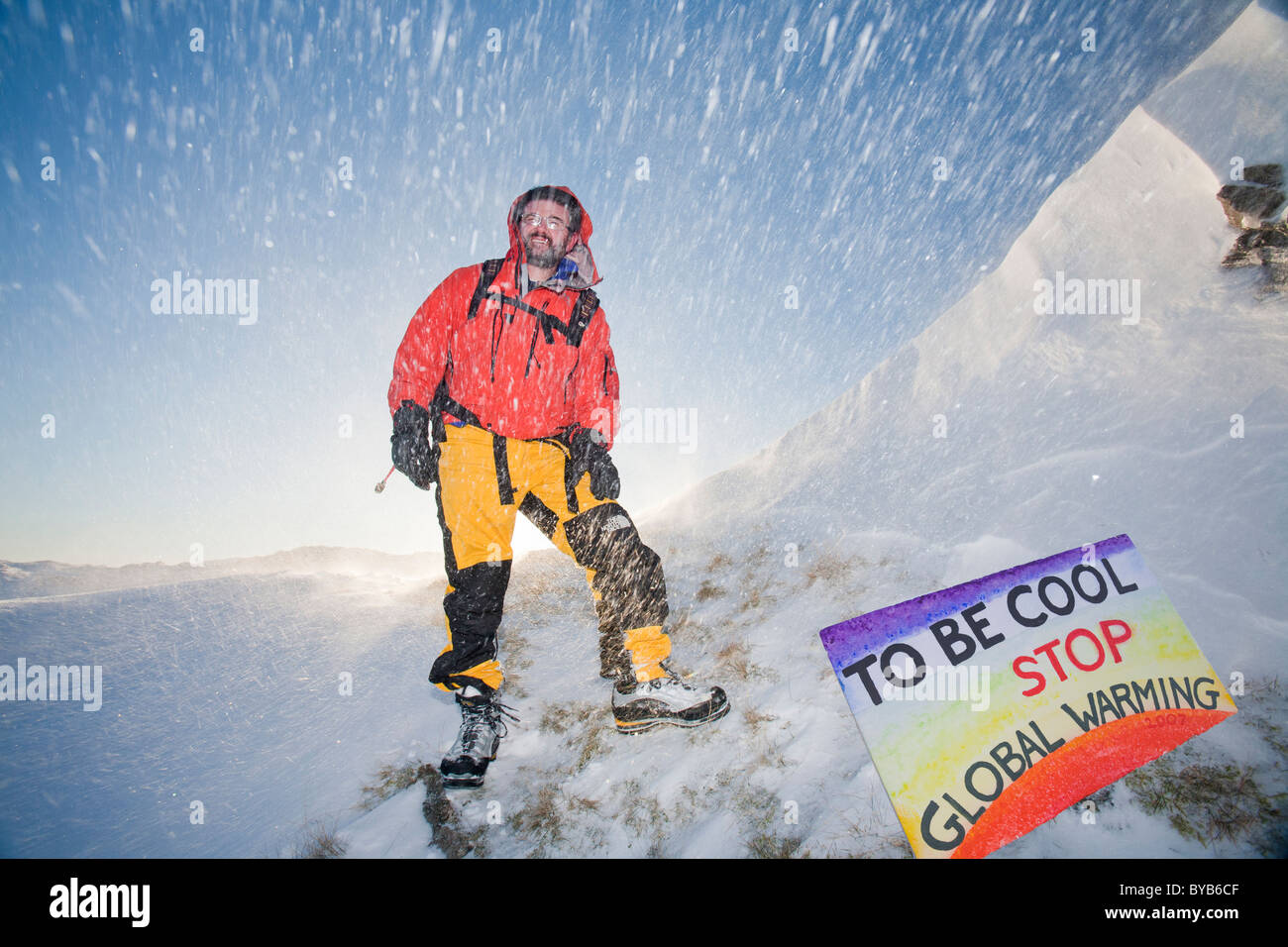 Ein Kletterer wird bei starkem Wind, Schnee oberhalb Grasmere im Lake District, UK Umzug von Spindrift gestrahlt. Stockfoto