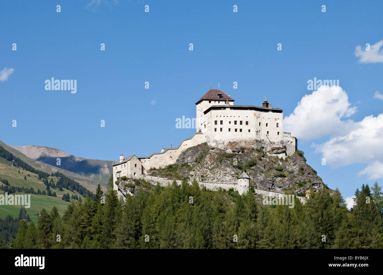 Bergpanorama mit Schloss Tarasp Schloss auf einem kegelförmigen Felsen-Hügel inmitten der Streusiedlung Tarasp Stockfoto
