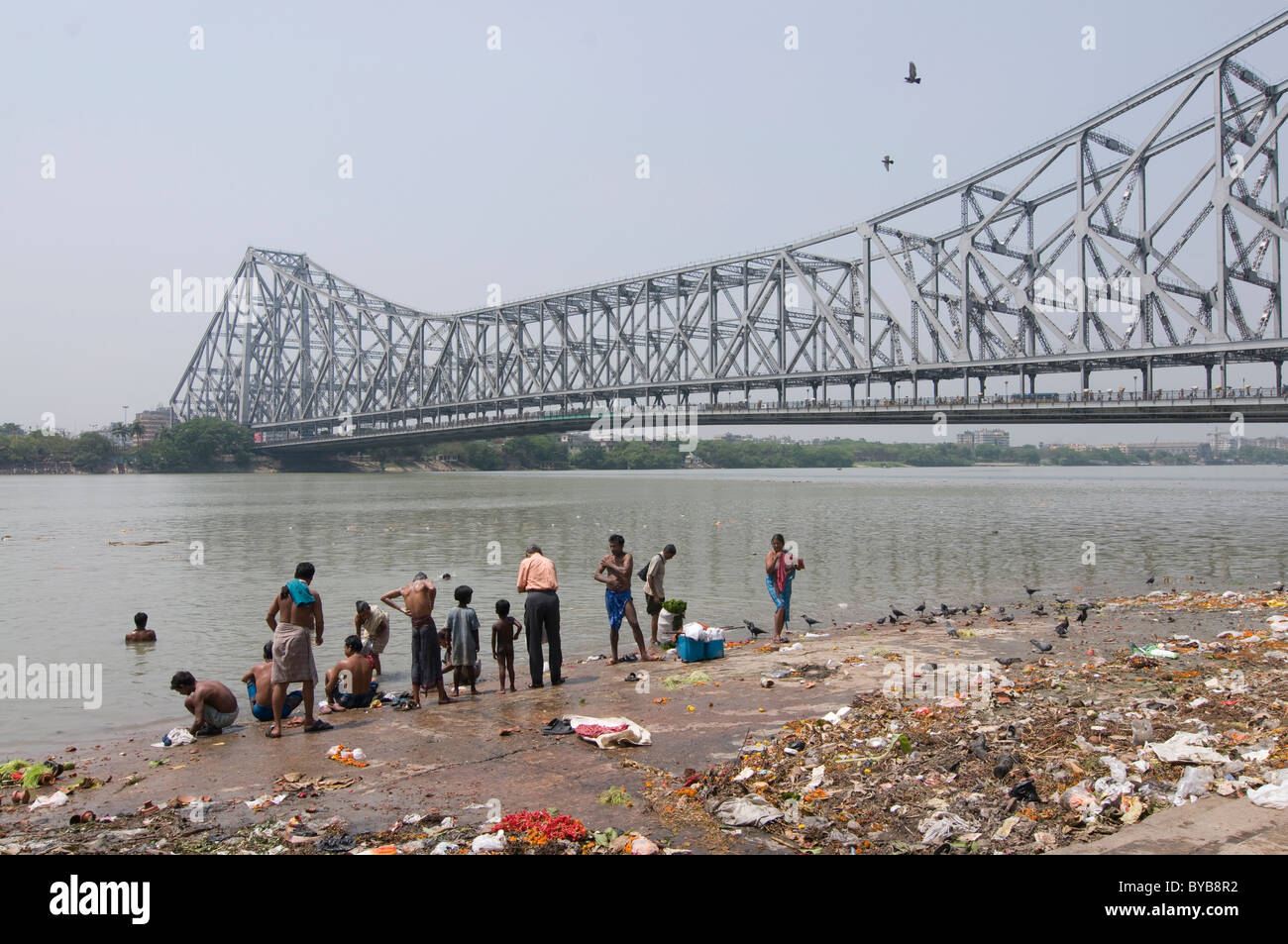 Menschen waschen sich im Fluss vor Howrah Bridge, Kalkutta, Kalkutta, Indien, Asien Stockfoto