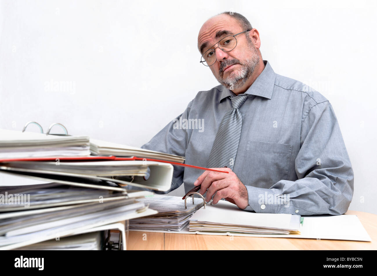 Eine arrogante Angestellte hinter seinem Schreibtisch sitzen Stockfoto