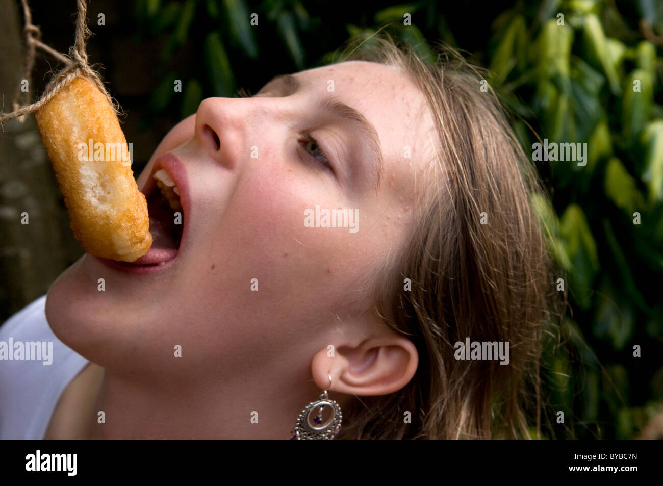 Kind essen Donuts aus einer Zeichenfolge Stockfoto