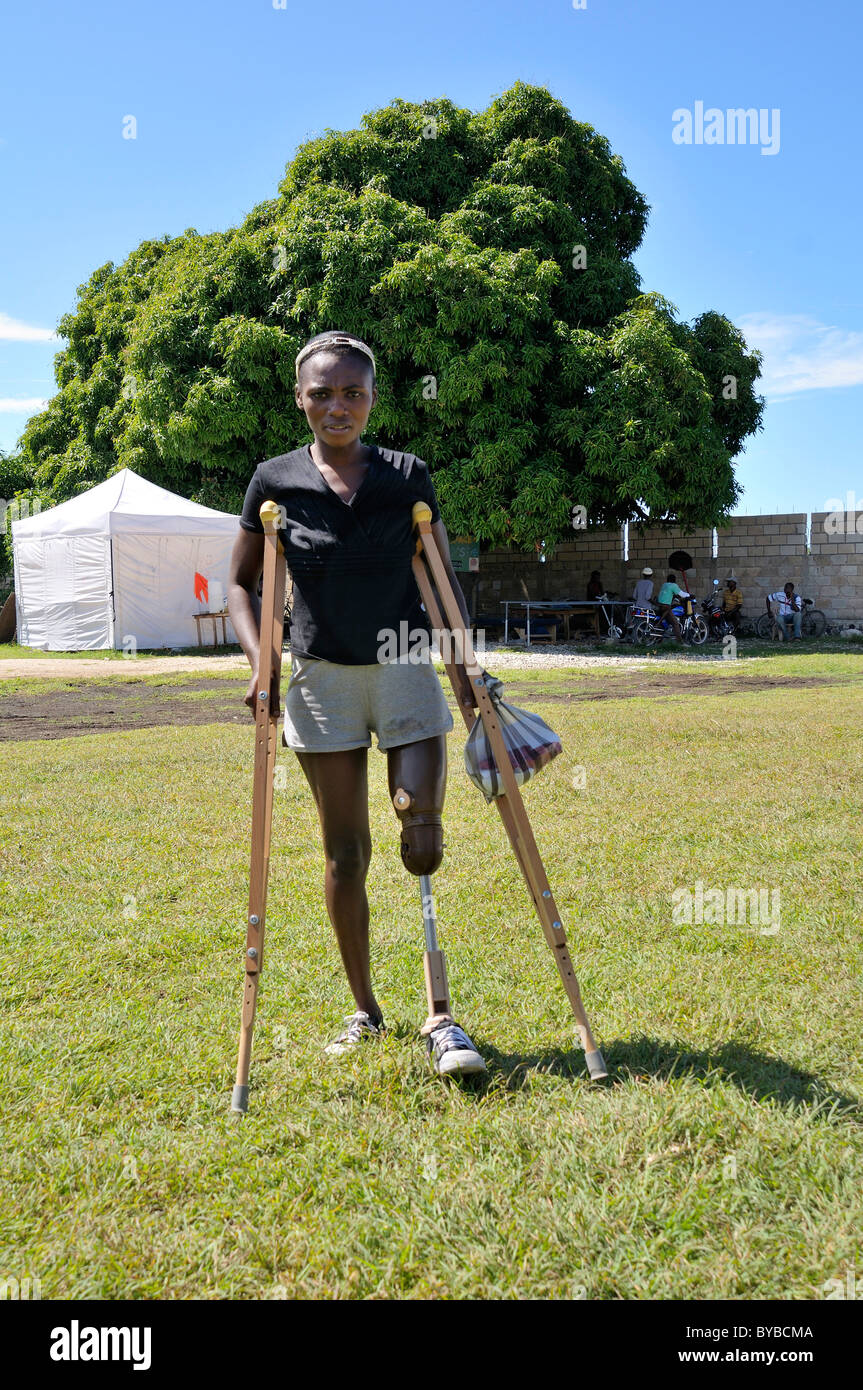 Junge Frau, die Opfer des Erdbebens Januar 2010 mit einer Beinprothese und Krücken, die sie von einem Relief erhalten Stockfoto
