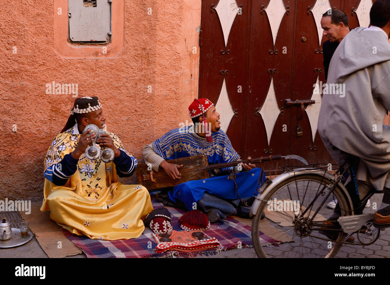 Paar gnawa Straßenmusikanten spielen und hajhuj krakeb in Marrakesch im Gespräch mit Passanten Marokko Stockfoto