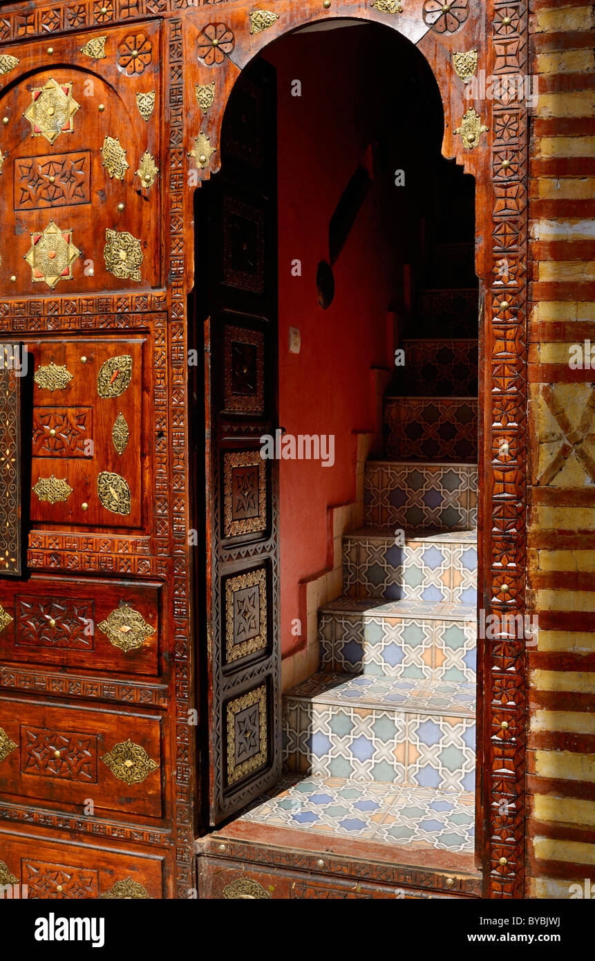 Kunstvoll geschnitztem Holz und Messing Tür mit Fliesen-Schritte im Marrakesch Medina Souks in Marokko Stockfoto