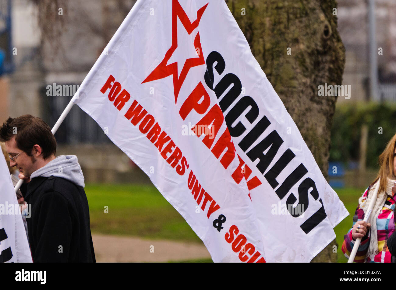 Mann trägt eine sozialistische Partei-Flagge Stockfoto
