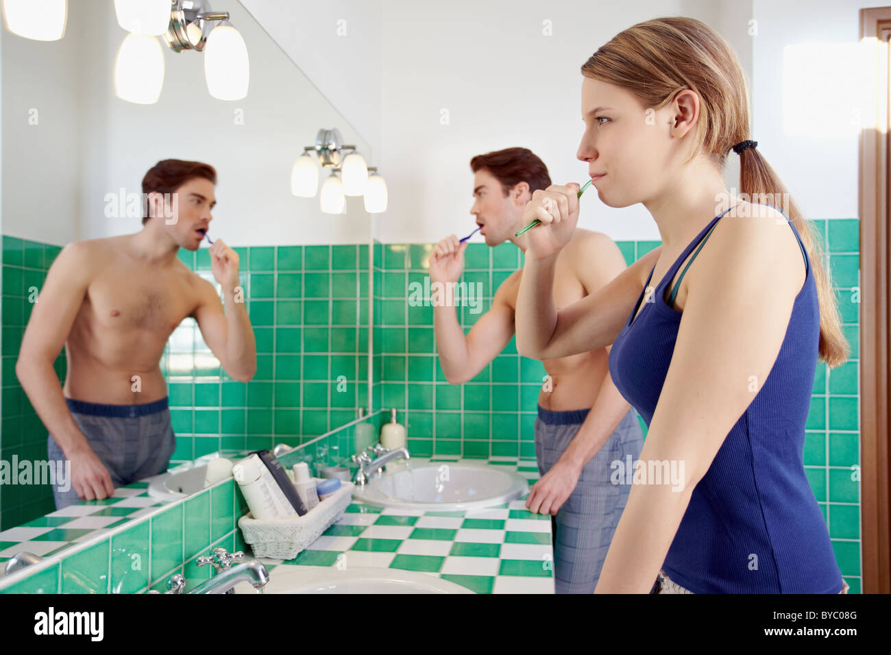 Kaukasische Heterosexuelles Paar Zähneputzen zusammen im Bad und Spiegel zu betrachten. Stockfoto