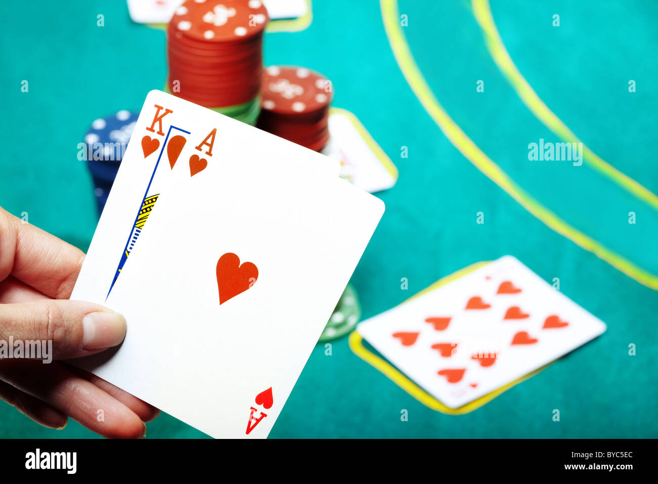 Menschliche Hand mit zwei Karten im Casino. Poker-Chips auf einem Hintergrund Stockfoto