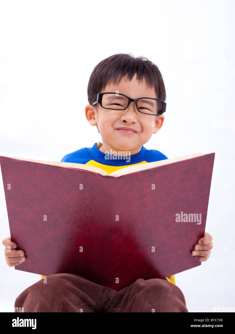 Fröhlicher Junge asiatische junge mit Buch Stockfoto