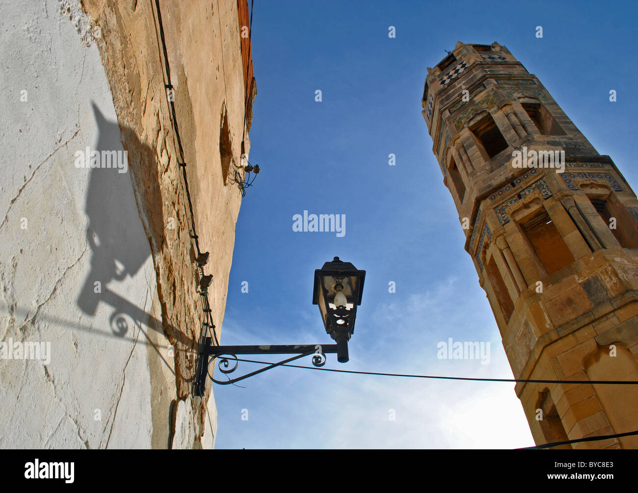 Minarett und Straßenlaterne mit Schatten in Medina von Sousse, Tunesien Stockfoto