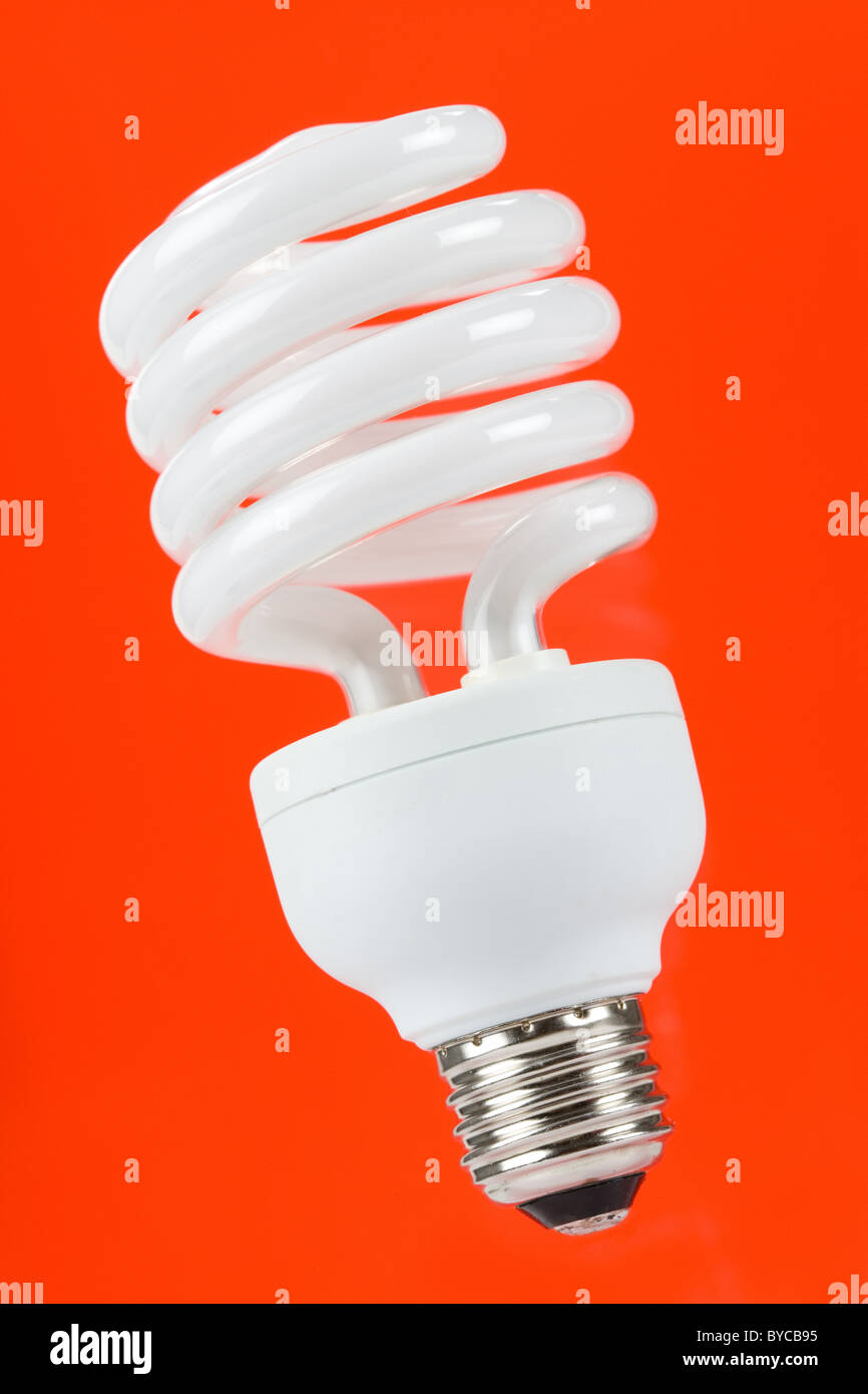 Compact Fluorescent Lightbulb mit rotem Hintergrund Stockfoto