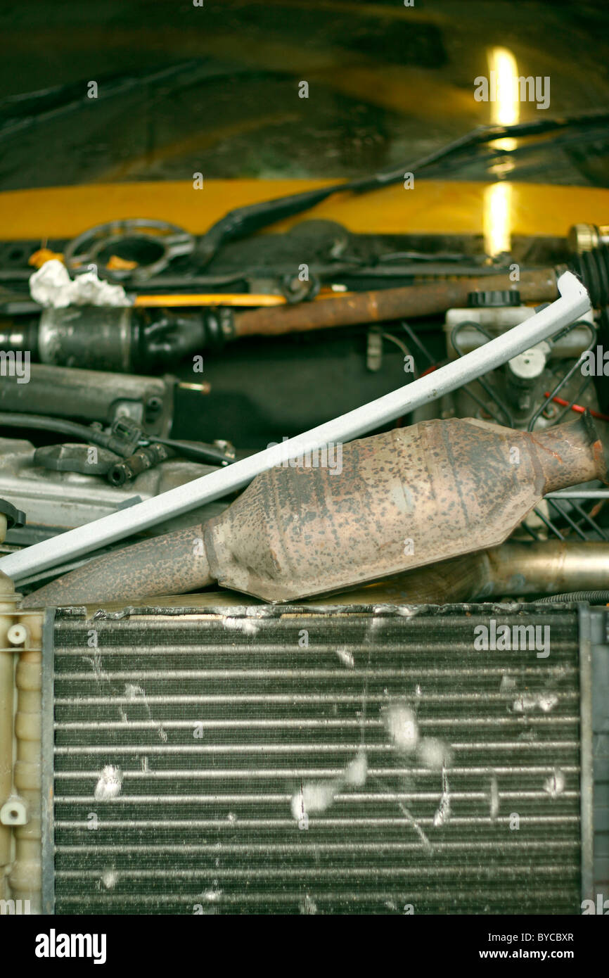 Den Kühler eines Autos in einer Garage und Katalysator der Abgasanlage unter einem Haufen von Werkzeugen. Stockfoto