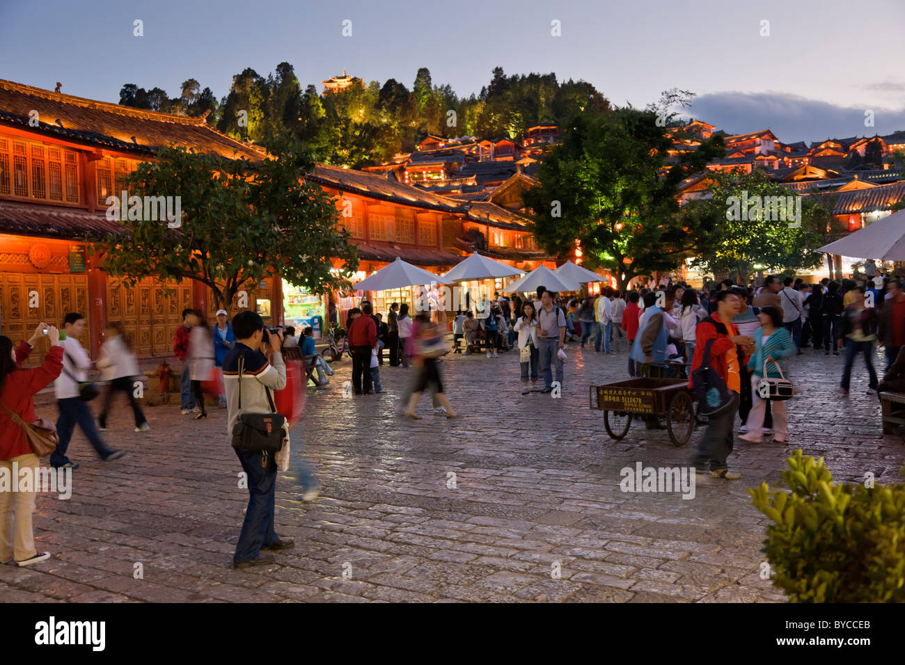 Einbruch der Dunkelheit mit Licht im Stein gepflastert alten Marktplatz in der Altstadt von Lijiang, Provinz Yunnan, China. JMH4760 Stockfoto