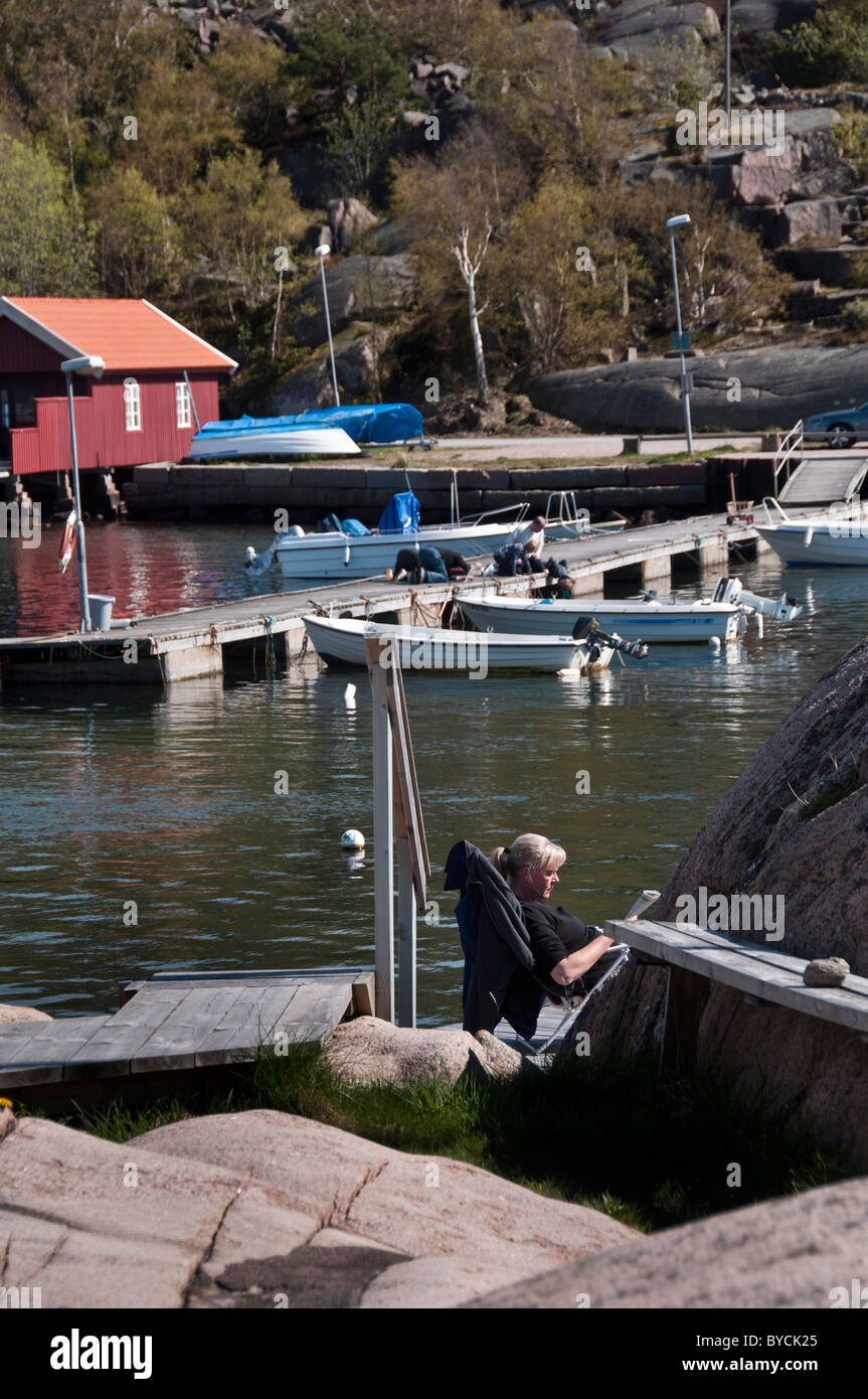 Frau in einem Liegestuhl unter in den frühen kann Sonnenschein in Bovallstrand in Bohuslän an der schwedischen Westküste Stockfoto