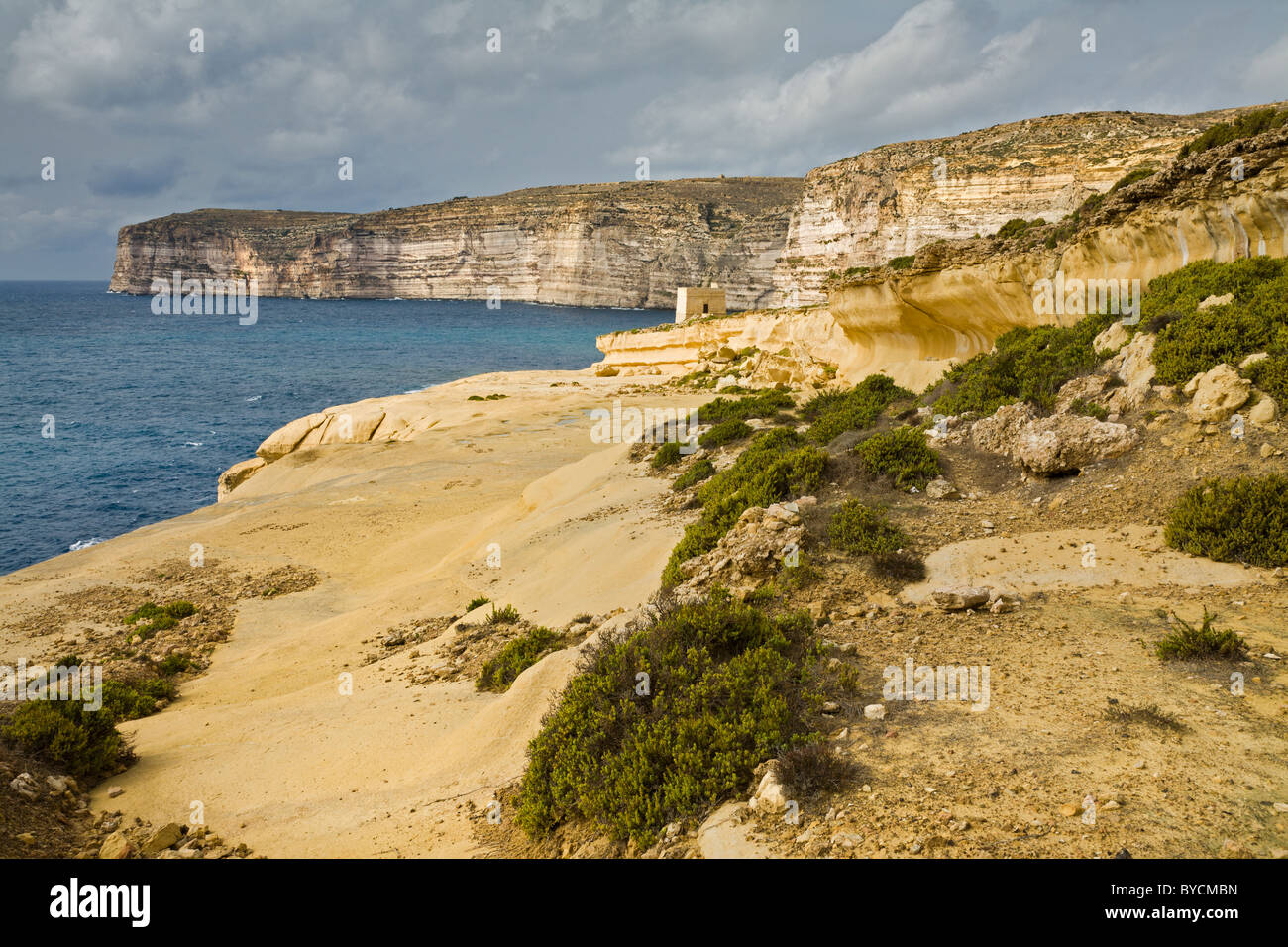 Die Klippen und ausgewaschene Felswände mit Xlendi Turm, Gozo, Malta. Stockfoto