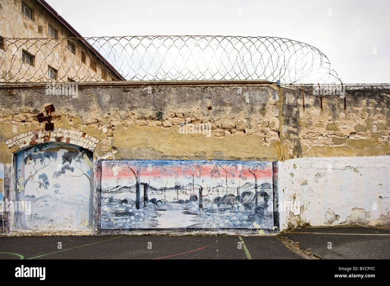Grimmige Wände des Übung Yard garniert mit Stacheldraht und dekoriert mit australischen Busch Szenen in Fremantle Gefängnis in der Nähe von Perth Stockfoto