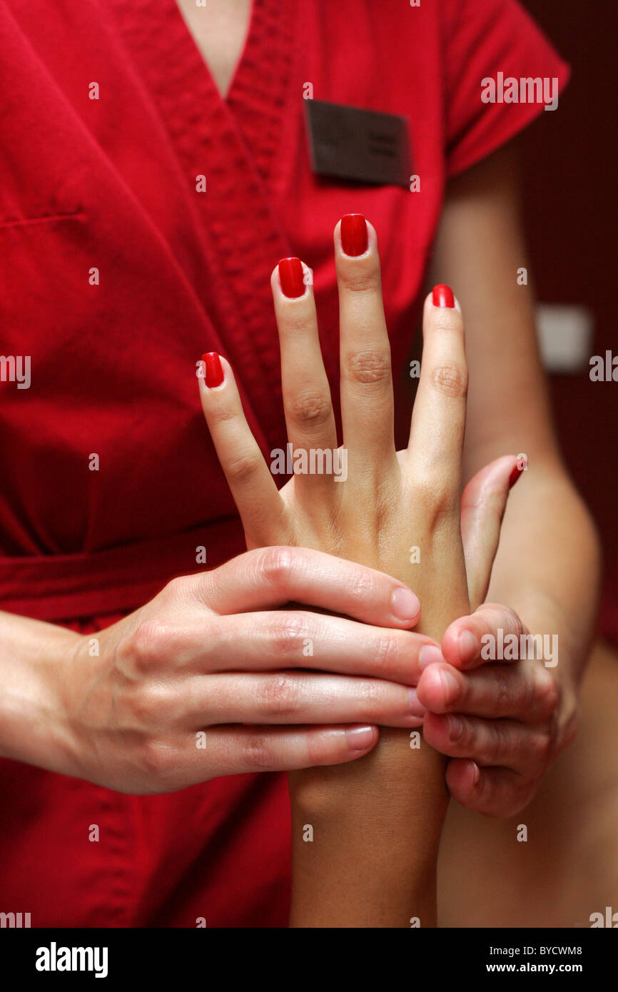 Frau massiert Frau die Hand. Stockfoto
