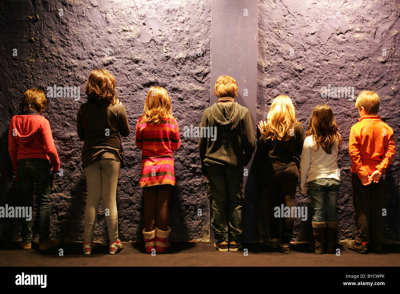 Rückansicht der Kinder vor einer Wand. Stockfoto