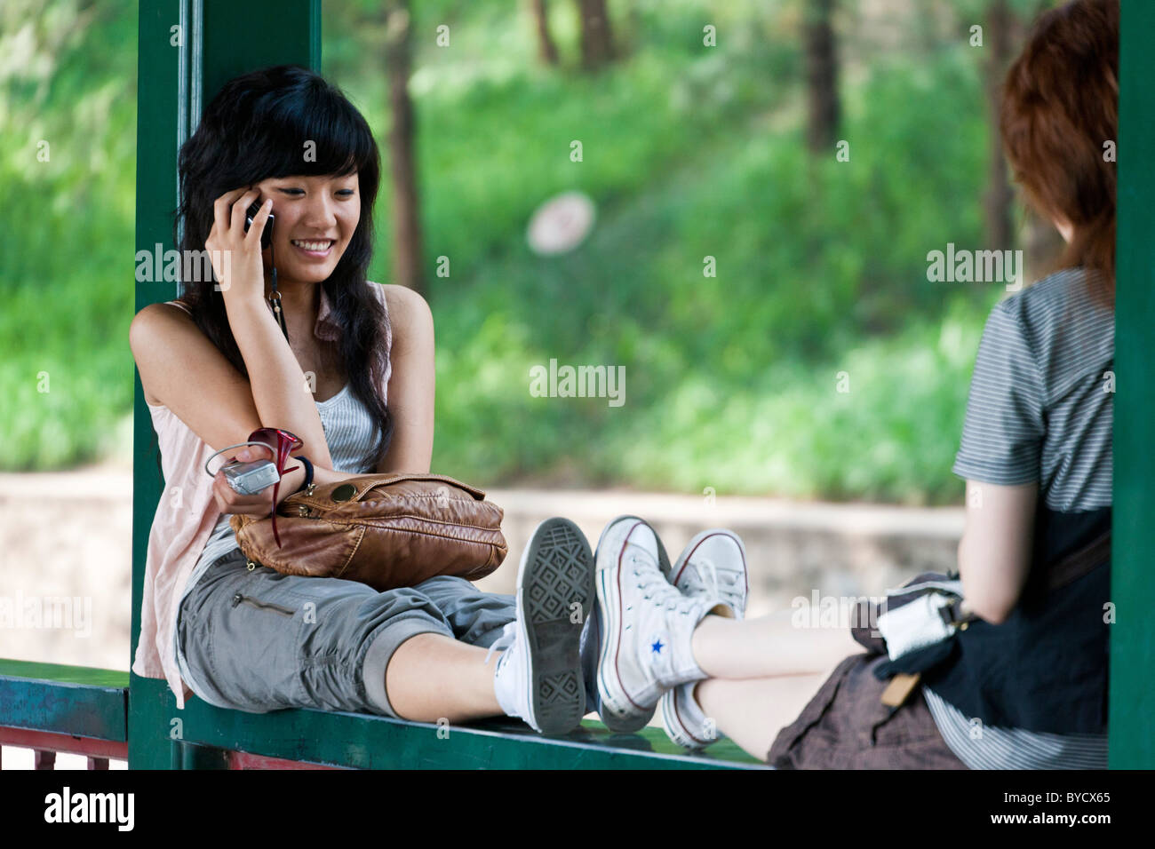 Attraktive junge Chinesin spricht über Handy auf dem Gelände des neuen Sommerpalast, Peking, China. JMH4806 Stockfoto