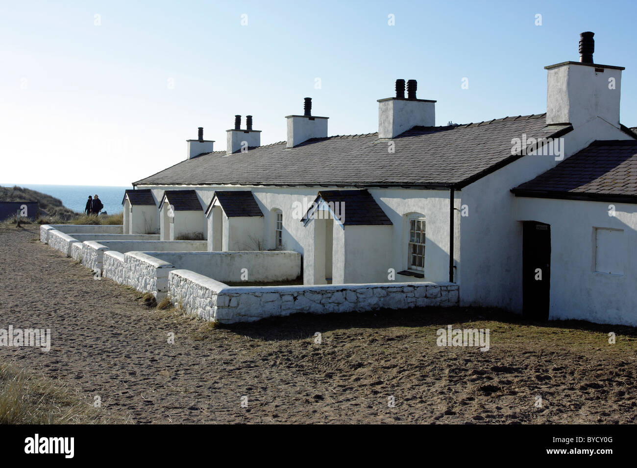 Eine Reihe von weiß getünchten, stillgelegten Piloten Hütten auf Llanddwyn Island, Anglesey, Nordwales Stockfoto