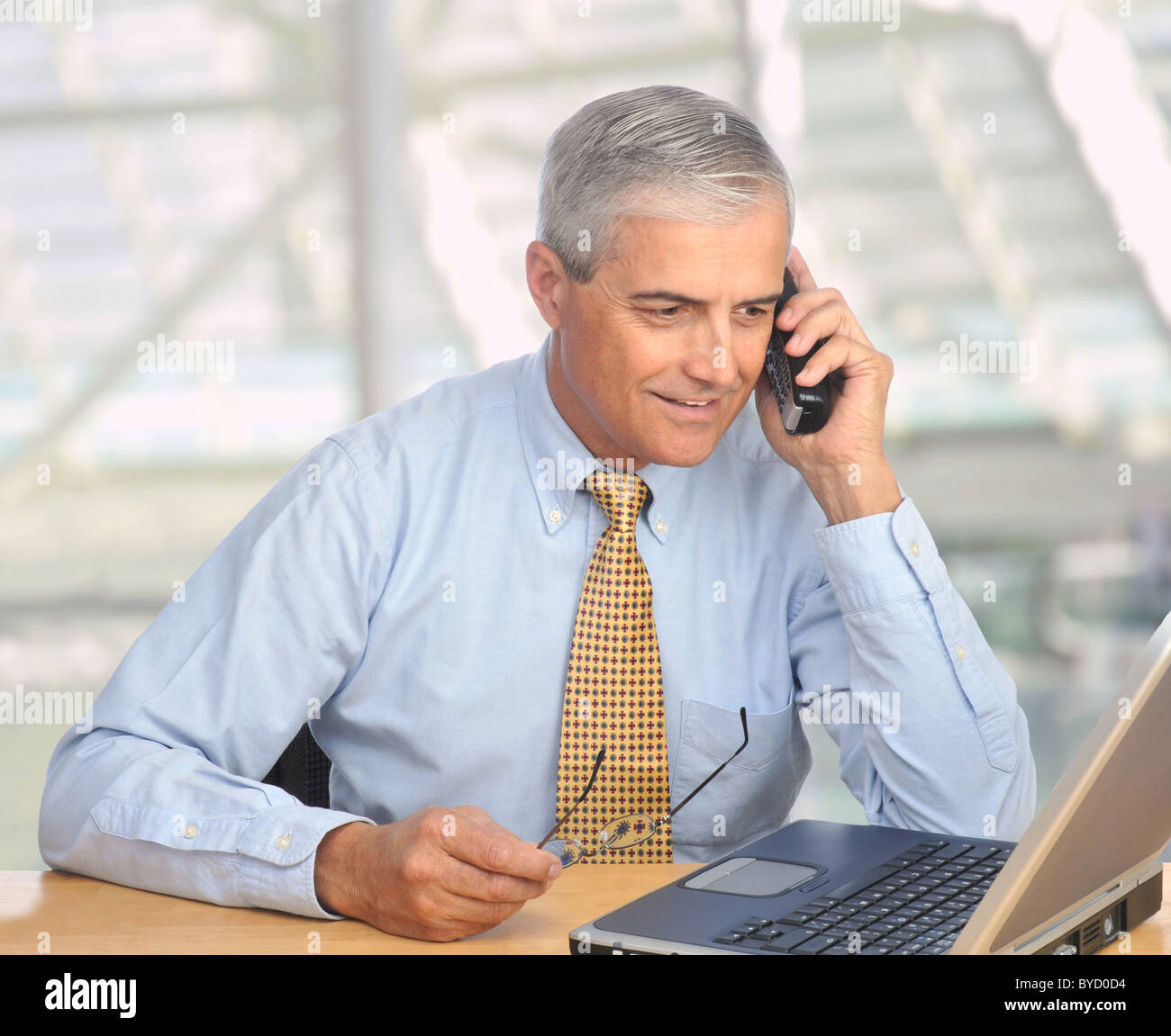 Applying Geschäftsmann mit Laptop am Telefon in modernen Büroumgebung sprechen. Stockfoto