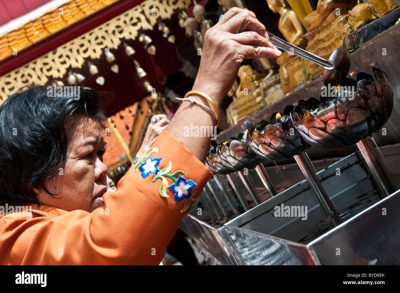 Frau, gießen Öl in Lotus brennen geformt Metalltrommeln, Wat Phra, die Doi Suthep, Chiang Mai, Thailand Stockfoto