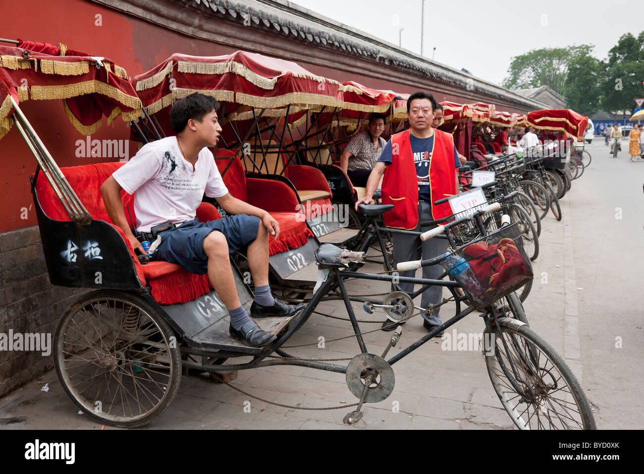 Fahrradrikschas warten auf Touristen auf einer Tour durch die Hutongs in Peking zu nehmen. JMH4839 Stockfoto