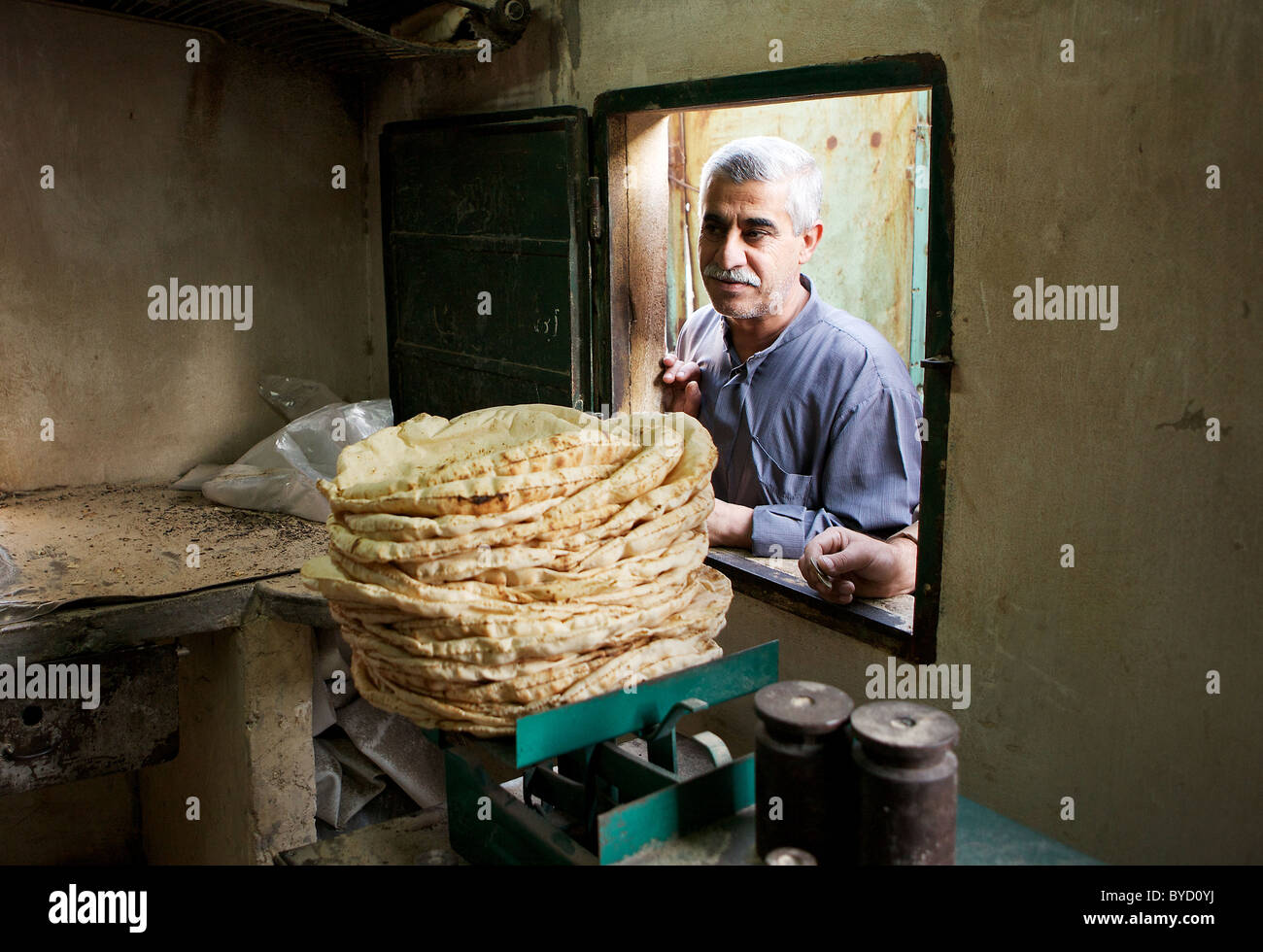 Ein Alter syrischen Mann wartet auf sein Brot in einer lokalen Backstreet-Bäckerei in Hama, Syrien Stockfoto