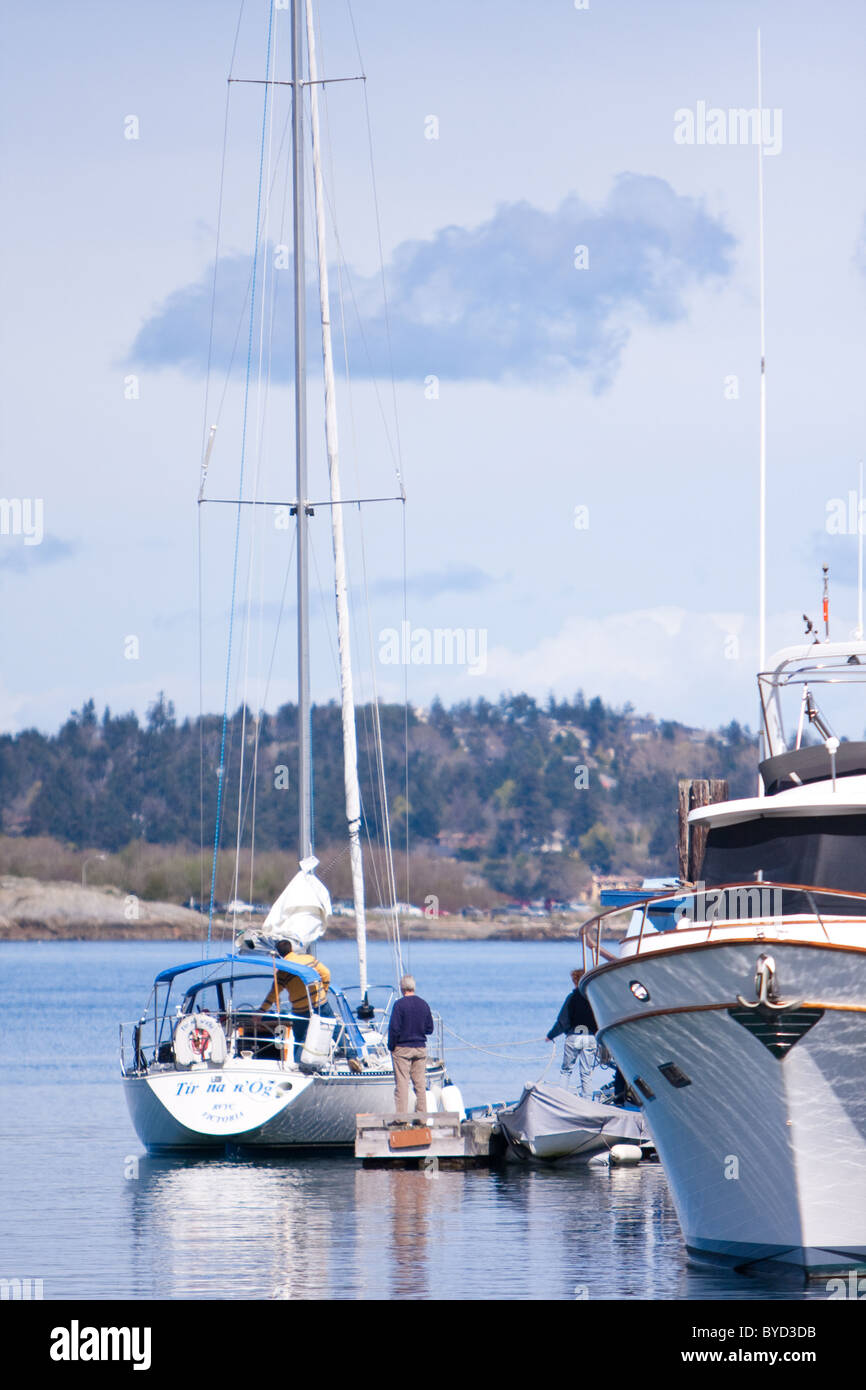 Menschen, die dazu neigt, ein Segelboot in Oak Bay Marina, BC, Kanada. Stockfoto