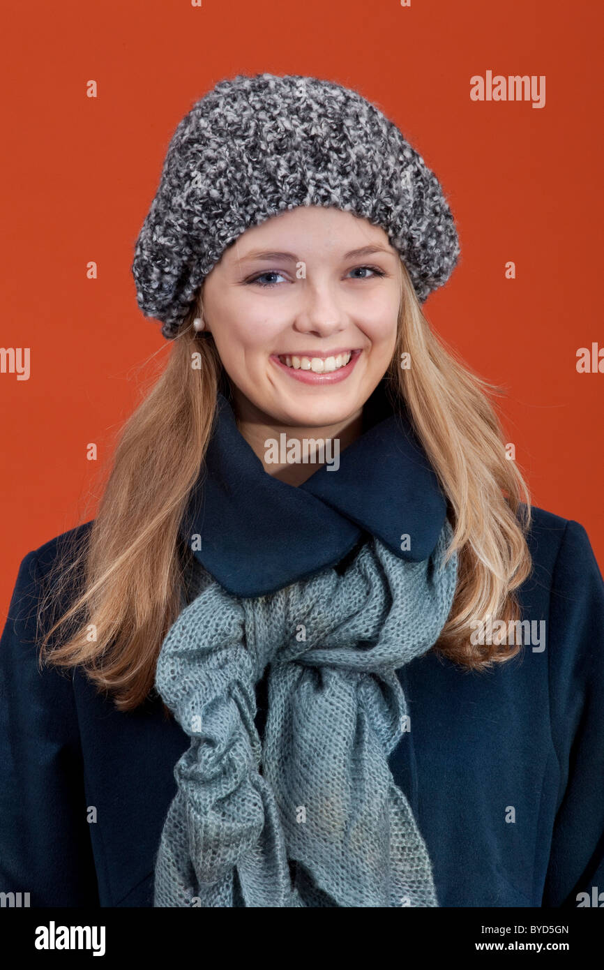 Lächelnde junge Frau mit Hut, Schal und Winter Mantel Stockfoto