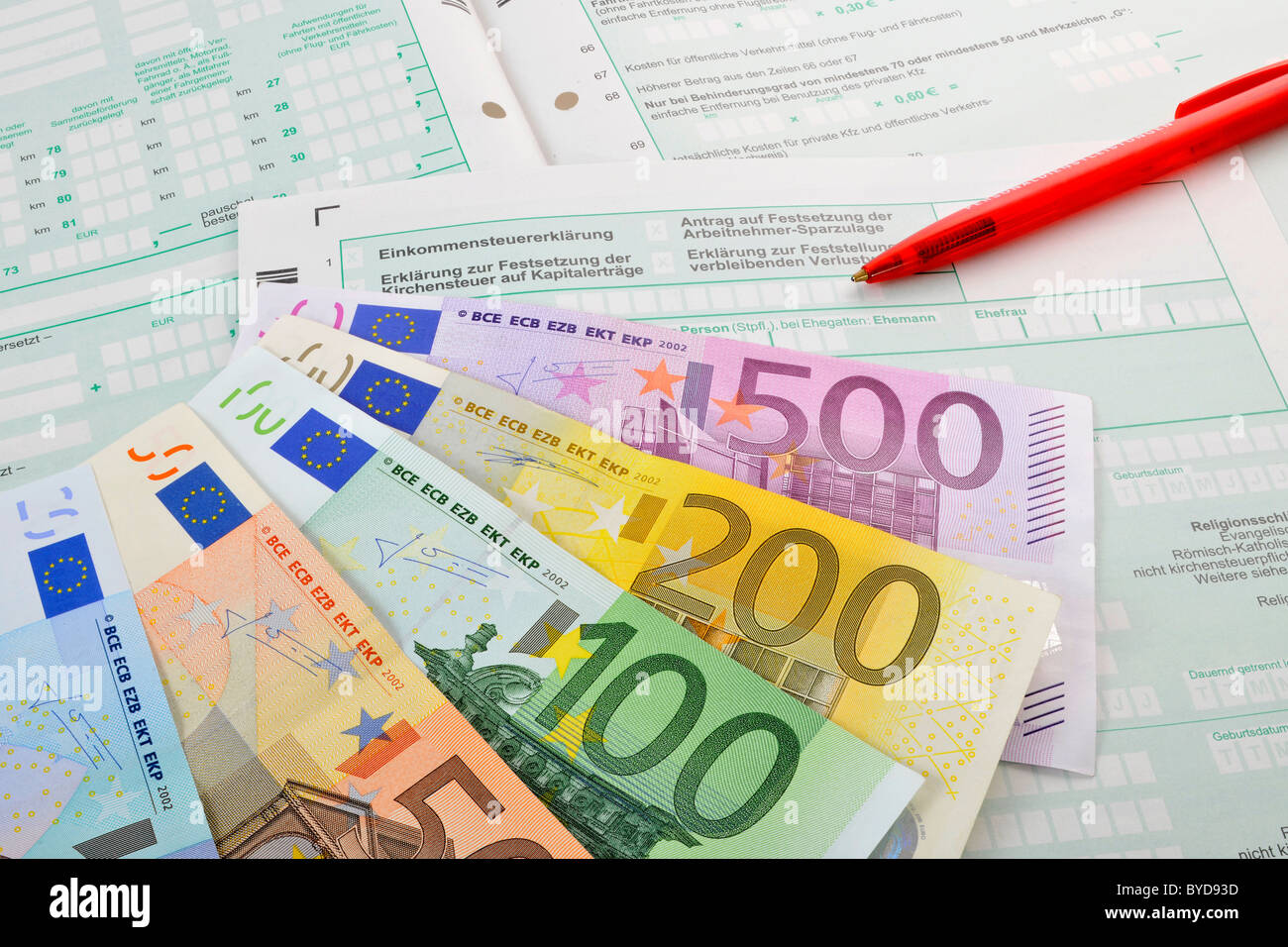 Fan von verschiedenen Euro-Banknoten und einem Stift auf den Formularen eine Einkommenssteuererklärung, symbolisches Bild für eine steuerliche Belastung, Einkommensteuer Stockfoto