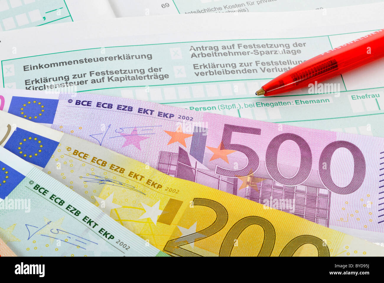 Fan von verschiedenen Euro-Banknoten und einem Stift auf den Formularen eine Einkommenssteuererklärung, symbolisches Bild für eine steuerliche Belastung, Einkommensteuer Stockfoto