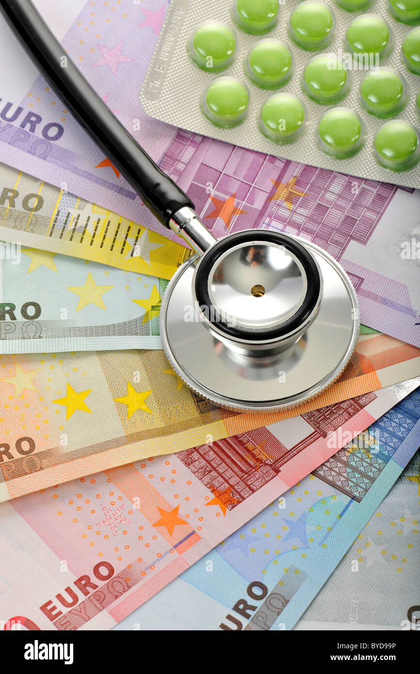 Pillen und ein Stethoskop auf ein Fan von Euro-Banknoten, symbolisches Bild für die Erhöhung der medizinischen Kosten Stockfoto
