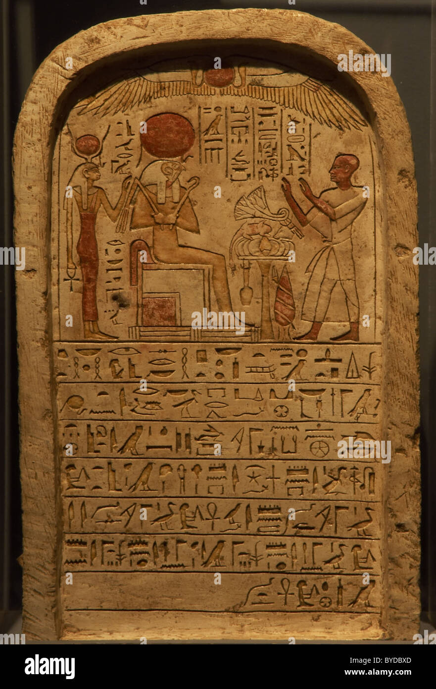 Ägyptische Kunst. Stele mit einem Priester eine Darbringung des Gottes Ra (sitzend, mit Falcon Kopf und Sonnenscheibe) Hinter Isis. Stockfoto