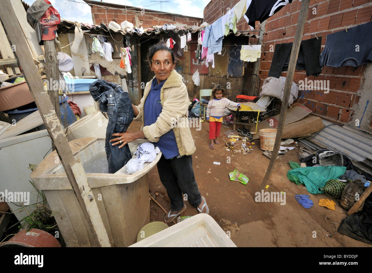 Schwangere Frau, 43, Wäschewaschen vor einer schäbigen Hütte in einer Favela oder Shanty Town, das Familienleben durch das sammeln, Stockfoto
