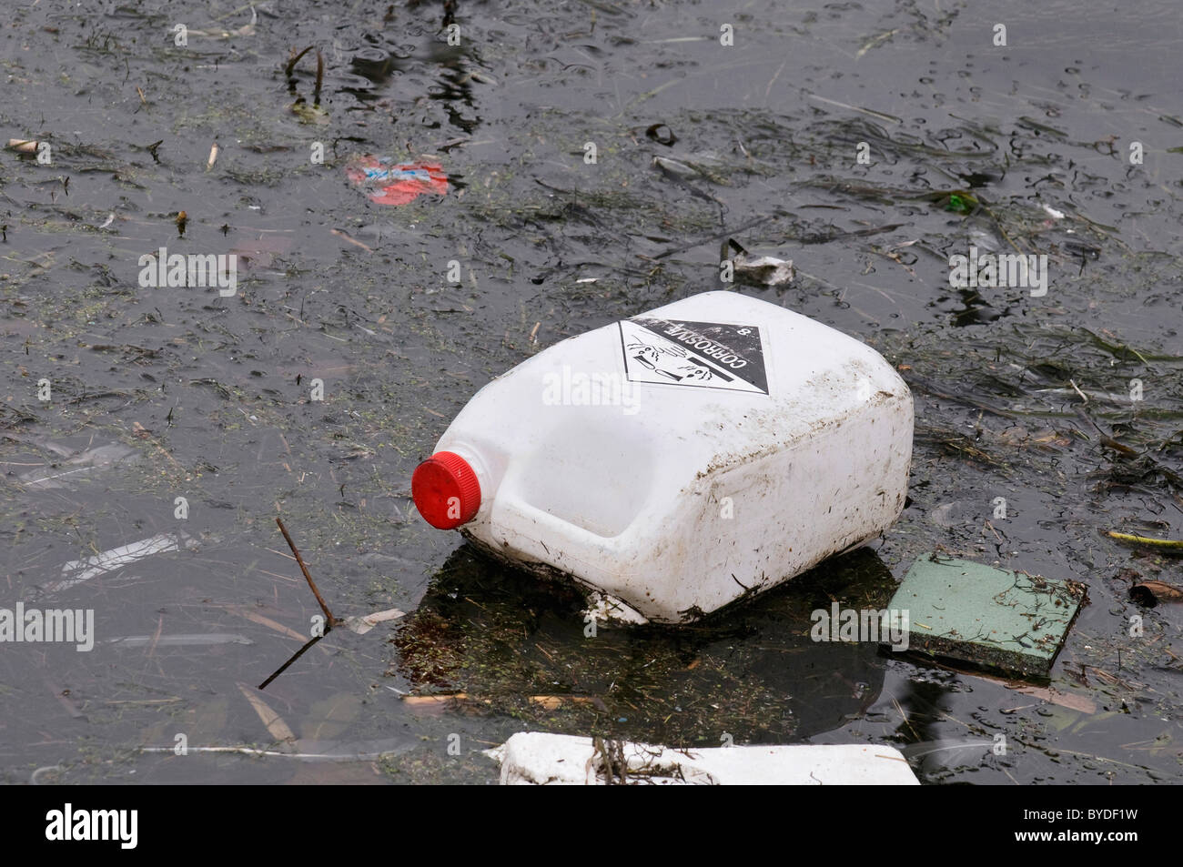Schmutziges Wasser, alten Kanister mit ätzenden Substanzen schwimmend auf schmutzigen film Stockfoto