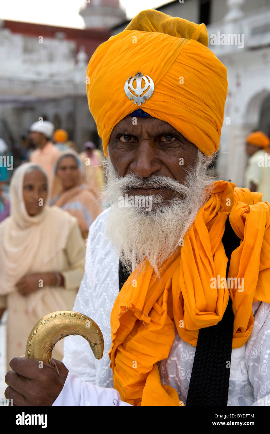 Sikhism, Gläubige Sikh mit orange Turban und Khanda Symbol, Heiligen goldenen Tempel, Hari Mandir, Amritsar, Punjab Stockfoto