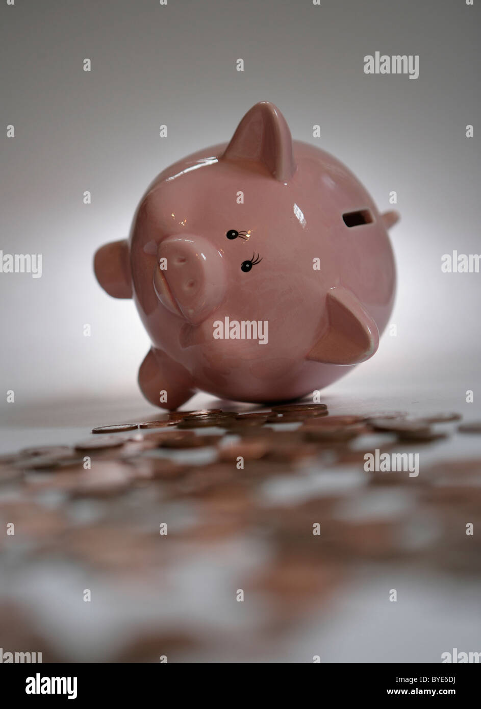 Ein Sparschwein, umgeben von Münzen. Stockfoto