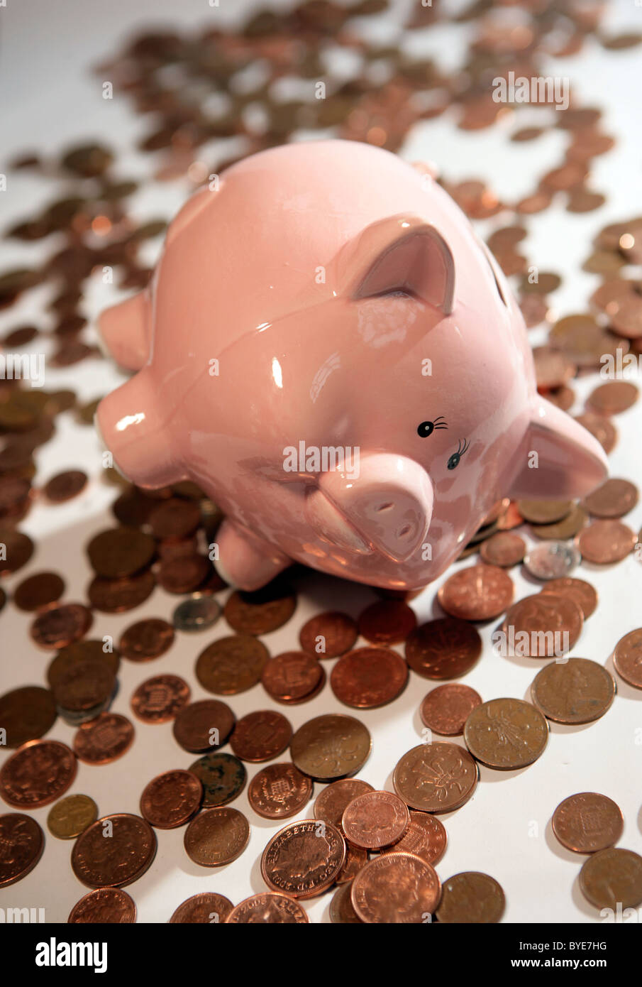 Ein Sparschwein, umgeben von Münzen. Stockfoto