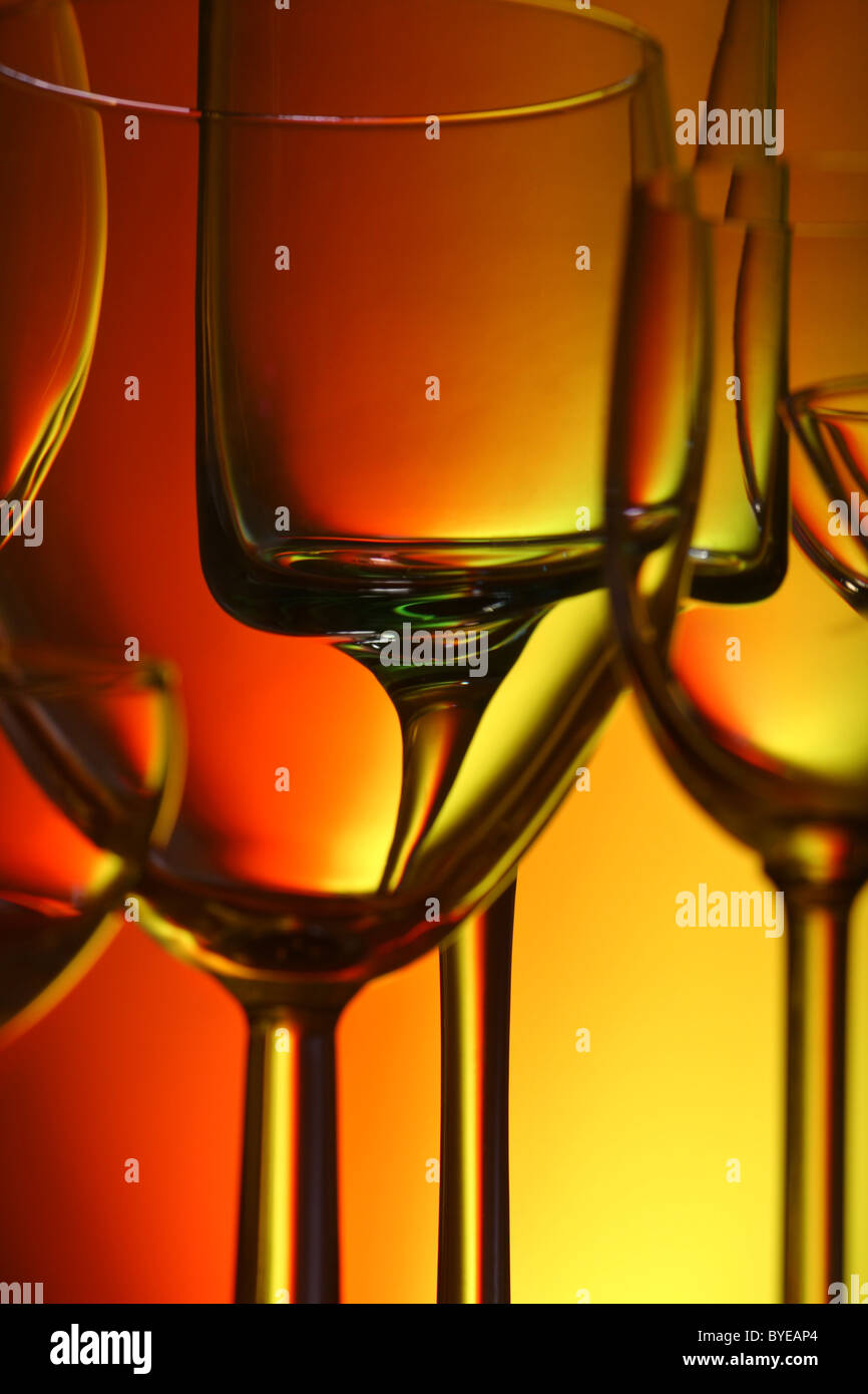 Eine Vielzahl von Gläsern, Hintergrundbeleuchtung mit farbigem Hintergrund, Fokus durch das Glas zu trinken Stockfoto